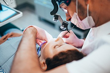 Dentist working on patient’s teeth with magnifiers