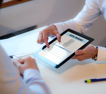 Two people looking at a dental insurance form on a tablet