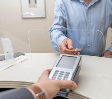 Person swiping their payment card at the front desk