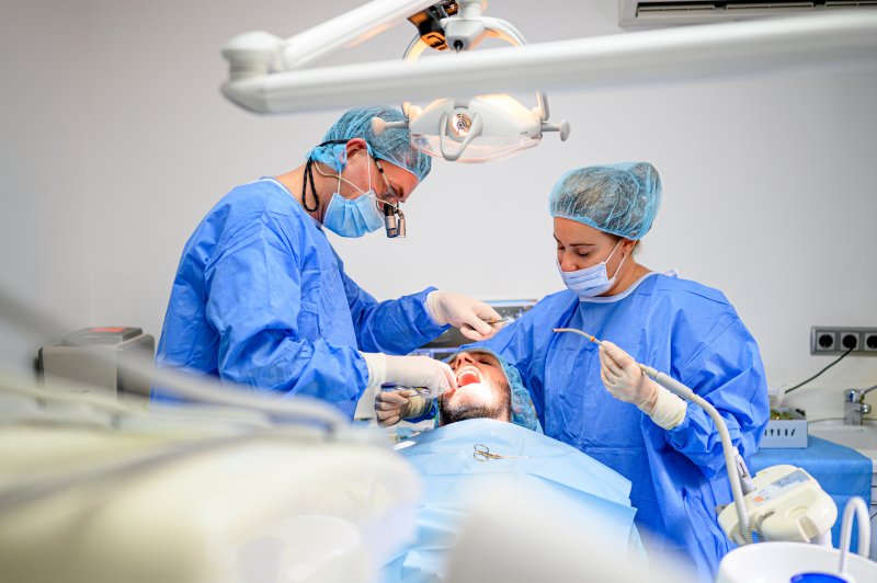 an oral surgeon performing dental implant surgery